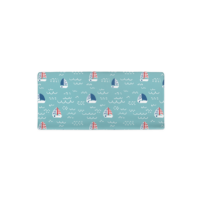 Top down view of changing pad cover with sailboat pattern on blue ocean doodle background.