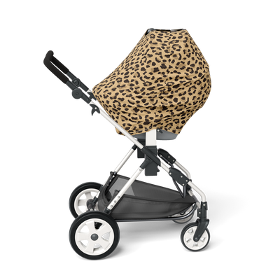 Side view of stroller with leopard print multi-use nursing cover over the seat.